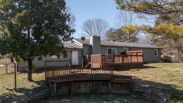 back of property featuring a wooden deck, a chimney, crawl space, fence, and a yard