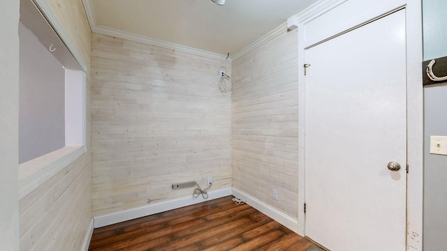 interior space with ornamental molding, wood walls, wood finished floors, and baseboards