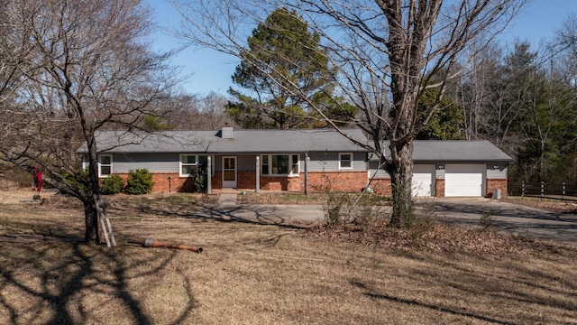 ranch-style home featuring a garage, brick siding, driveway, and a chimney