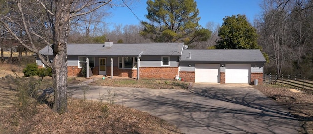 ranch-style home featuring concrete driveway, brick siding, and fence