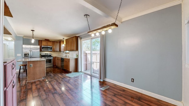 kitchen featuring dark wood-style floors, visible vents, appliances with stainless steel finishes, ornamental molding, and a kitchen bar