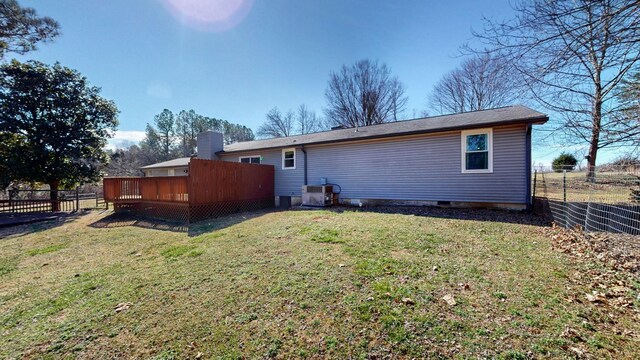 back of property with a yard, fence, and a wooden deck