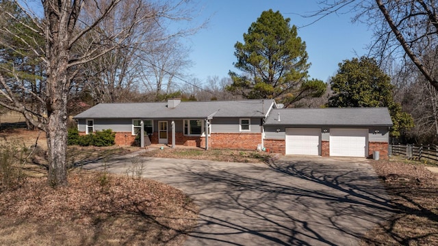 ranch-style house with driveway, a chimney, an attached garage, fence, and brick siding