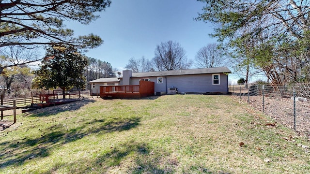 rear view of property featuring crawl space, a fenced backyard, a lawn, and a wooden deck