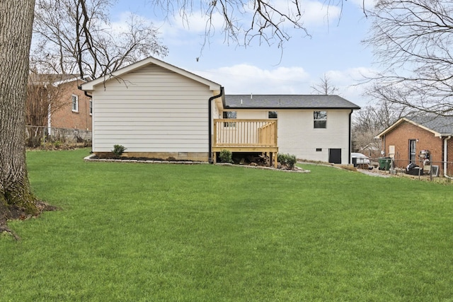 rear view of house with a lawn and a deck