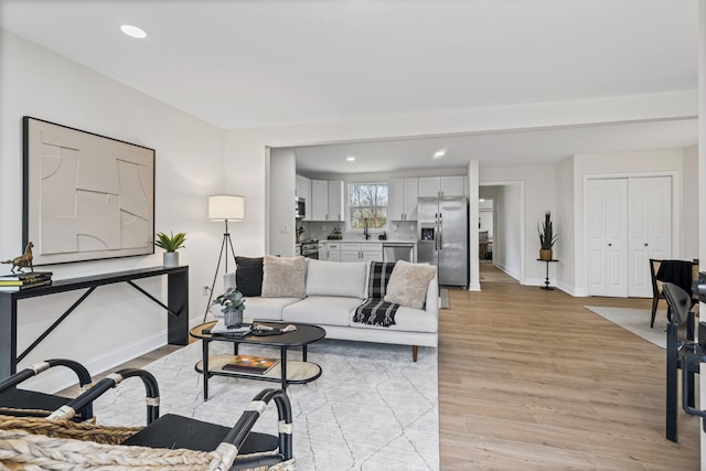 living room with light wood-type flooring and sink