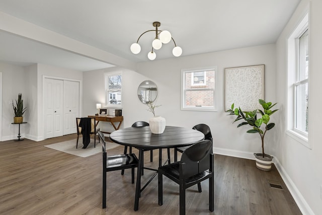 dining room featuring dark wood-type flooring and an inviting chandelier