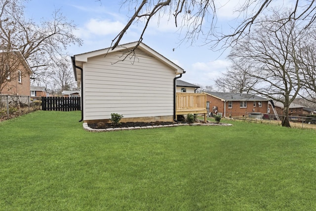 view of side of property with a lawn and a wooden deck