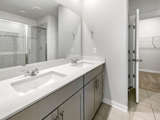 bathroom featuring tile patterned flooring, vanity, and a shower with shower door