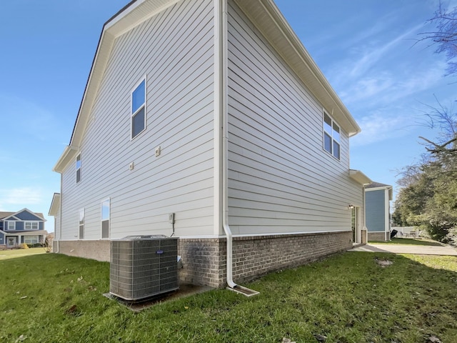 view of property exterior with a yard and cooling unit