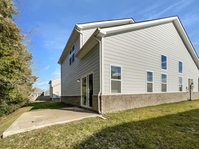 view of side of property with a lawn and a patio area