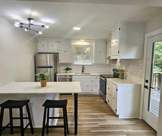 kitchen with stainless steel appliances, white cabinetry, and sink