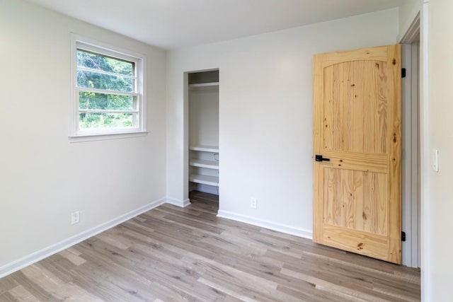 unfurnished bedroom with light hardwood / wood-style floors and a closet