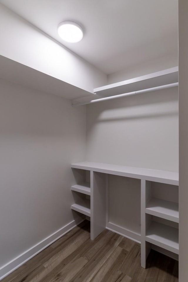 walk in closet with dark wood-type flooring