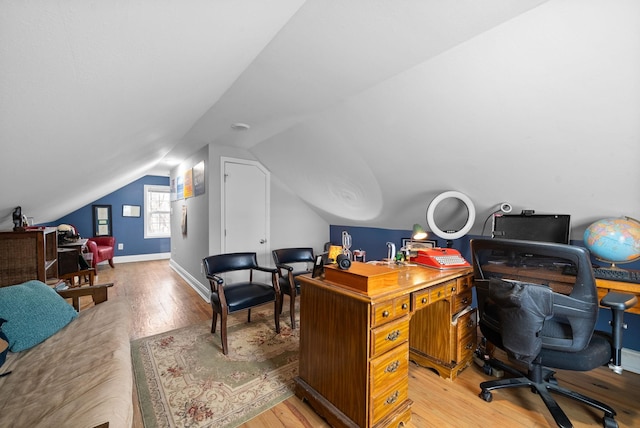 home office featuring hardwood / wood-style floors and vaulted ceiling