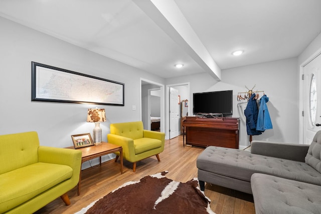 living room featuring beam ceiling and light wood-type flooring