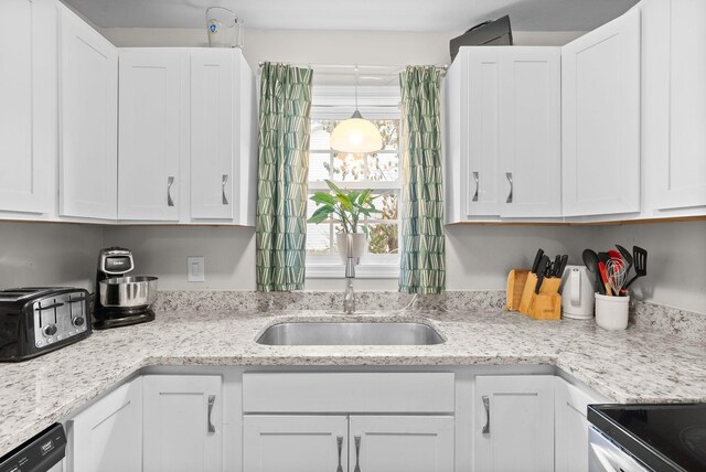 kitchen featuring dishwasher, white cabinets, sink, hanging light fixtures, and light stone countertops