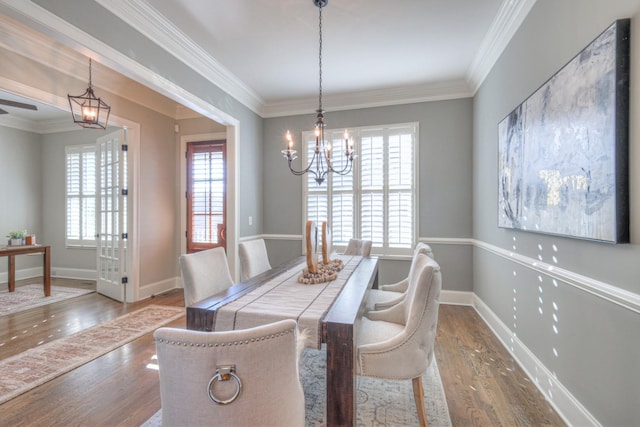 dining room featuring a wealth of natural light, an inviting chandelier, wood-type flooring, and ornamental molding