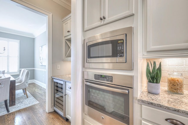 kitchen with white cabinetry, light stone countertops, light wood-type flooring, and appliances with stainless steel finishes