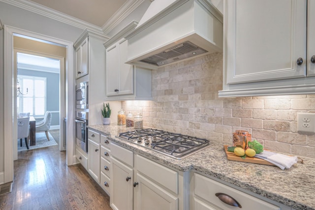 kitchen featuring decorative backsplash, white cabinets, stainless steel appliances, and custom range hood