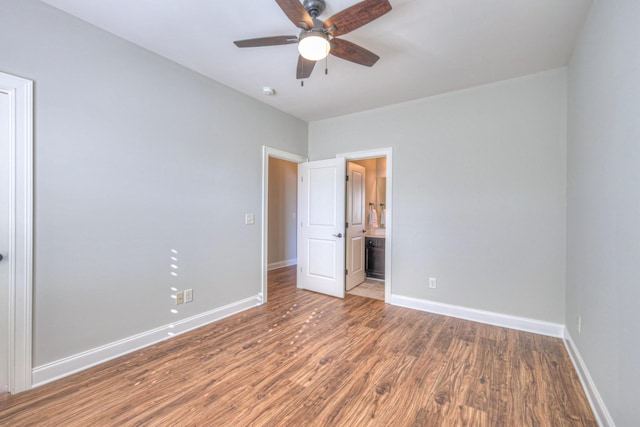 unfurnished bedroom with ensuite bathroom, hardwood / wood-style floors, and ceiling fan