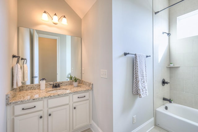 bathroom featuring vanity, lofted ceiling, and tiled shower / bath