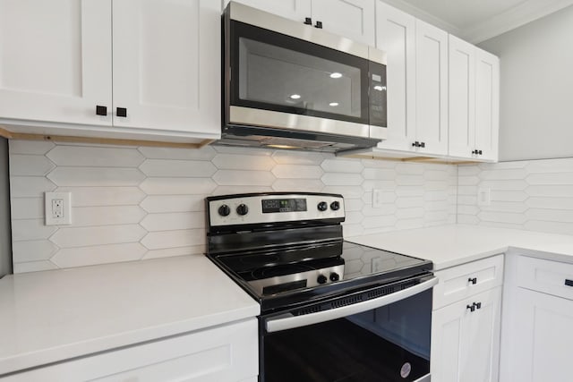 kitchen with light countertops, range with electric cooktop, white cabinets, and stainless steel microwave