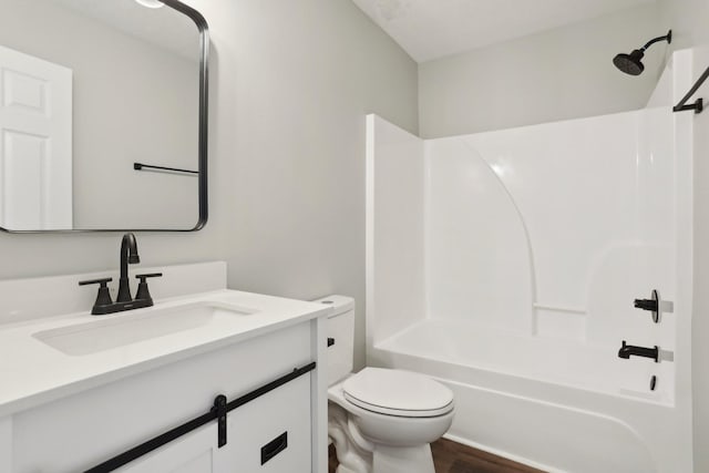 full bathroom with vanity, hardwood / wood-style flooring, shower / washtub combination, and toilet