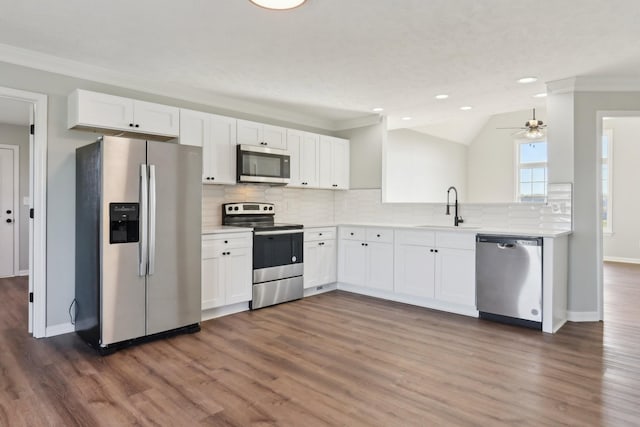 kitchen with a sink, white cabinets, light countertops, appliances with stainless steel finishes, and backsplash