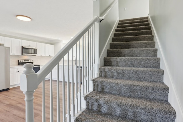 staircase featuring wood finished floors and floor to ceiling windows