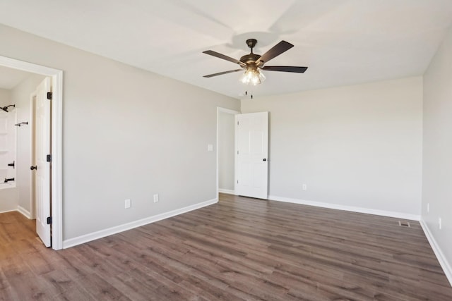 unfurnished room featuring ceiling fan, wood finished floors, and baseboards