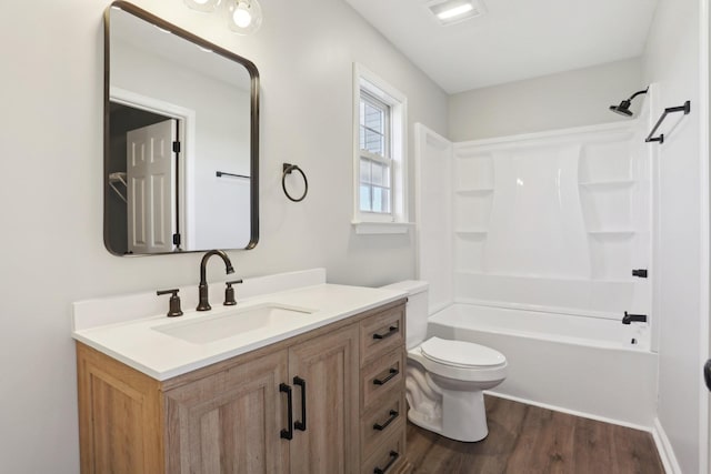 full bath with bathtub / shower combination, vanity, toilet, and wood finished floors