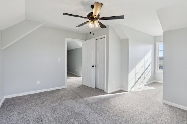 additional living space with ceiling fan and light colored carpet