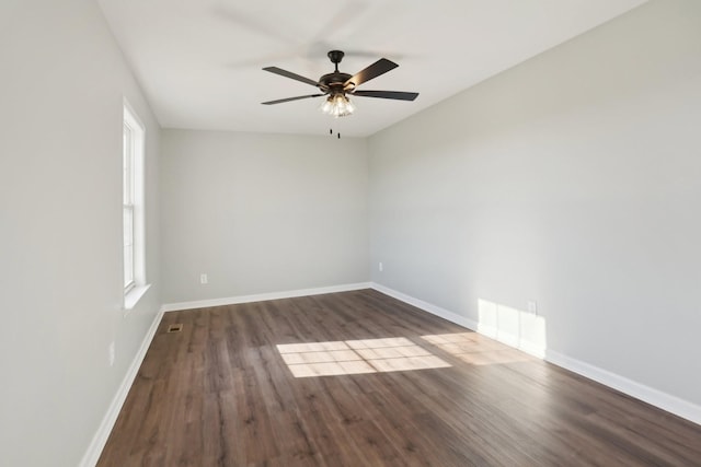 unfurnished room with a ceiling fan, baseboards, visible vents, and wood finished floors