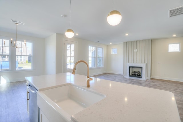 kitchen featuring stainless steel dishwasher, pendant lighting, and sink