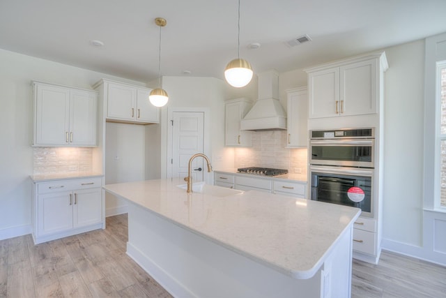 kitchen featuring white cabinetry, sink, hanging light fixtures, stainless steel appliances, and custom exhaust hood