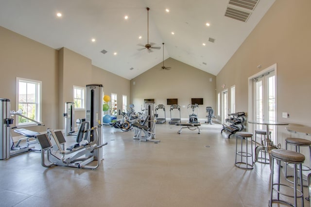 exercise room featuring ceiling fan and high vaulted ceiling