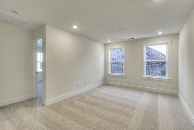 unfurnished room featuring light colored carpet and a healthy amount of sunlight