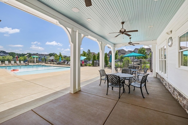 view of patio with ceiling fan and a community pool