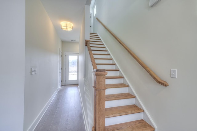 staircase with hardwood / wood-style flooring