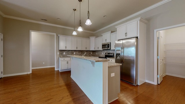 kitchen featuring white cabinets, an island with sink, decorative light fixtures, light stone counters, and stainless steel appliances