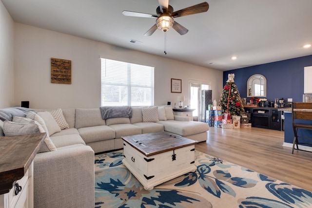 living room with light hardwood / wood-style floors and ceiling fan