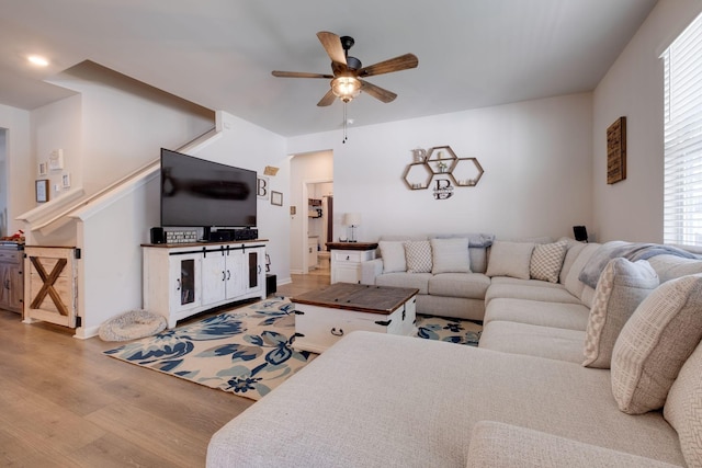 living room featuring ceiling fan and light hardwood / wood-style flooring