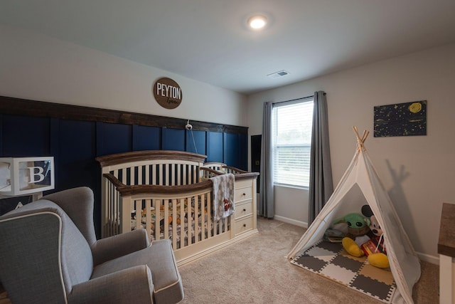 bedroom with light colored carpet and a crib