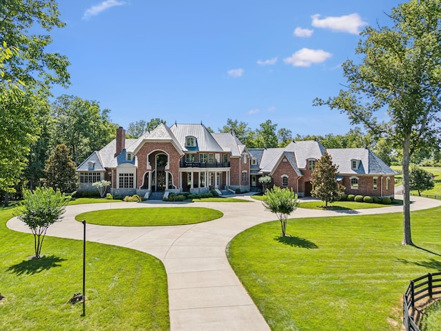 english style home with a front yard and a balcony