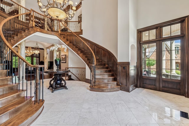 foyer entrance with a chandelier, french doors, and a high ceiling