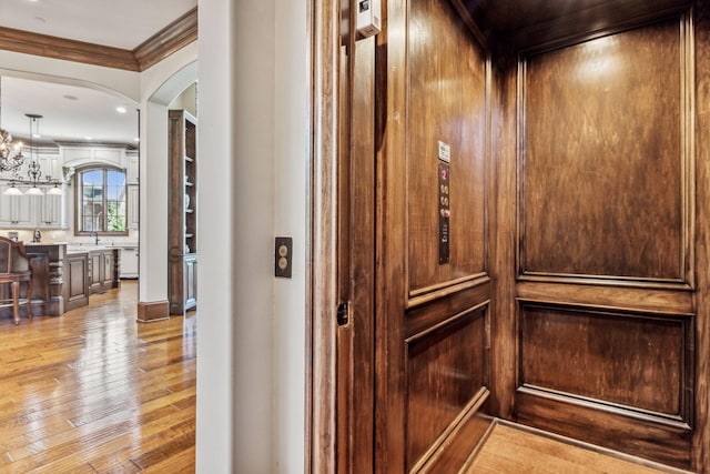 room details featuring wood-type flooring, crown molding, and elevator