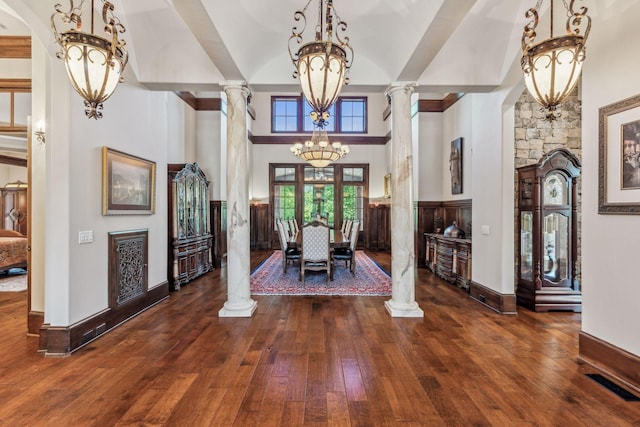 entrance foyer with dark hardwood / wood-style flooring, a high ceiling, and decorative columns