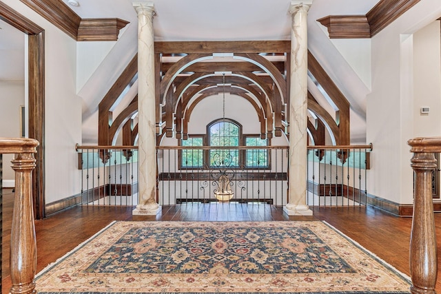 interior space featuring a high ceiling, dark hardwood / wood-style flooring, and ornate columns