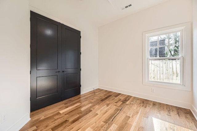 unfurnished bedroom featuring light hardwood / wood-style floors and a closet